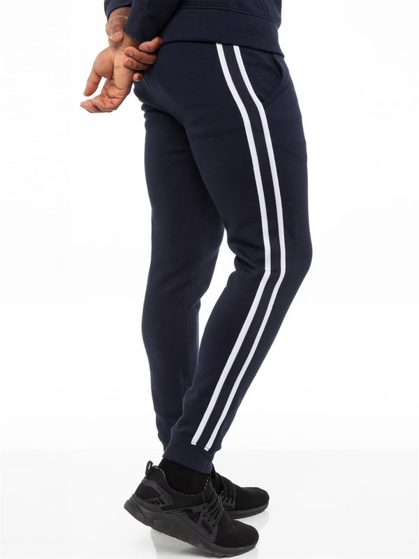 Enzo Mens Tape Hoodie Full Zip Tracksuit. Zip Through Hooded Top. Enzo Embroidery Logo on Chest and Contrast Stripe Design on Sleeves. Hoodie with Drawstring. Ribbed Waist and Cuffs. Kangaroo Pockets. Enzo Mens Casual Designer Striped Tracksuit Joggers. Featuring Classic Contrast Stripes to Sides. 2 Side Pockets. Cotton Blend for Superior Comfort. Adjustable Waist with Drawstrings. Athleisure Perfect for All Gym wear