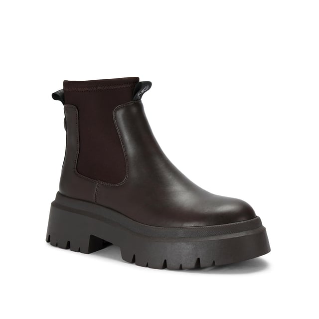 The KG Kurt Geiger Thea is a brown boot with chunky style, there is a stretch ankle for slip-on ease. The sole is extra chunky with large tread. the back of the ankle features a brown monocle and KG Kurt Geiger branded tape.