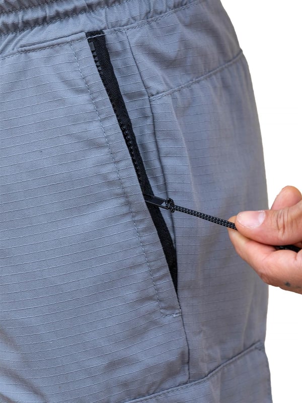 Expertly designed with top-quality ripstop fabric, these Enzo technical cargo shorts offer unparalleled durability. The convenient cargo pockets and zip side pockets make for easy storage, and the elasticated waistband with an adjustable drawstring ensures a comfortable fit. Upgrade your wardrobe and gear with this must-have for any outdoor enthusiast.