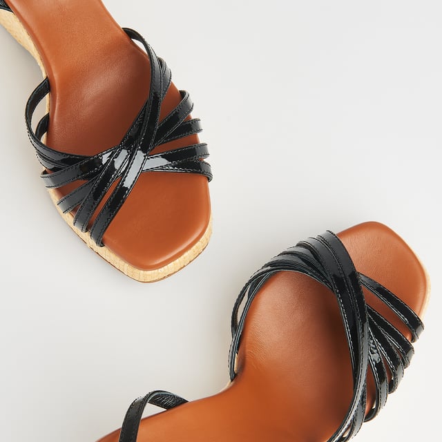 LK Bennett SOLANGE Sandals, Black With a hint of Seventies' playfulness, our Solange wedges balance height and comfort. Crafted in Italy from black patent leather, they have a crossover multi-strap design, a delicate ankle strap and a beige raffia 110mm wedge sole. Perfect with summer's cool cotton and linen skirts and dresses, they're also great with wide leg trousers.