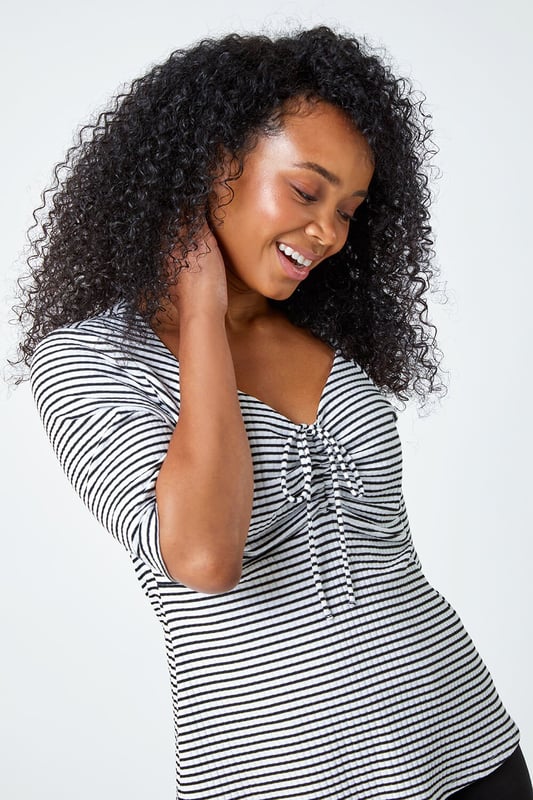 Petite Stripe Ruched V-Neck Stretch Top from Roman. Embody daytime glamour with this timeless Petite piece! Our newest addition to the Petite collection is this cutesy stripe top, it features a unique sweetheart neckline and playful 3/4 length sleeves that are sure to make a versatile staple ready for your Spring wardrobe. This Petite top has a timeless ribbed texture which accompanies the stripe print throughout as well as a tie detail at the bust that provides a sophisticated flare. Wear with shorts and sandals for a holiday-ready style.