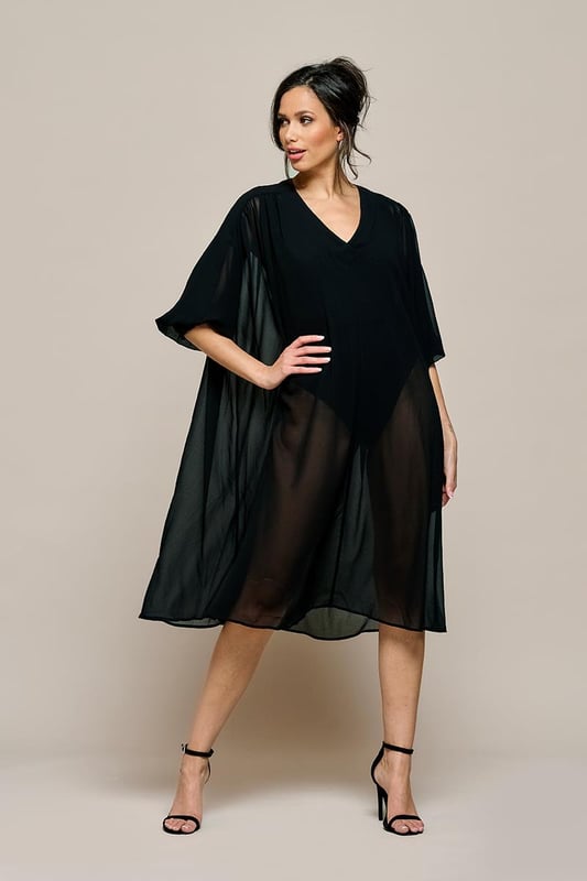 Kies voor elegantie en comfort met deze modieuze zwarte kaftan. Deze zomerse kaftan met driekwart mouwen heeft elegante, wijd uitlopende mouwen die nonchalant over de schouders vallen. De tijdloze zwarte kleur maakt dit kledingstuk een trendy aanvulling op elke garderobe. Het elastiek aan de onderkant zorgt voor een smock-effect, terwijl de diepe V-hals en oversized pasvorm de kaftan een modieuze uitstraling geven. Gemaakt van semi-transparante voile stof met bijpassende onderjurk voor een luchtig effect, terwijl de bijpassende losse ceintuur de taille mooi accentueert. Dit oversized model biedt een casual en comfortabele look, terwijl je toch volledig vrouwelijk blijft.