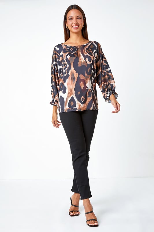 Abstract Print Blouson Sleeve Top from Roman. Elevate your casual collection this season with this luxurious woven top. Bringing a glamorous energy to your daytime style, this top is adorned in an abstract print that's filled with Autumnal hues making it perfect for the upcoming season. Designed with a round neckline which features a playful keyhole cut-out and full-length blouson sleeves that ooze feminine energy. Wear with smart trousers and heels for the perfect desk-to-dinner style.