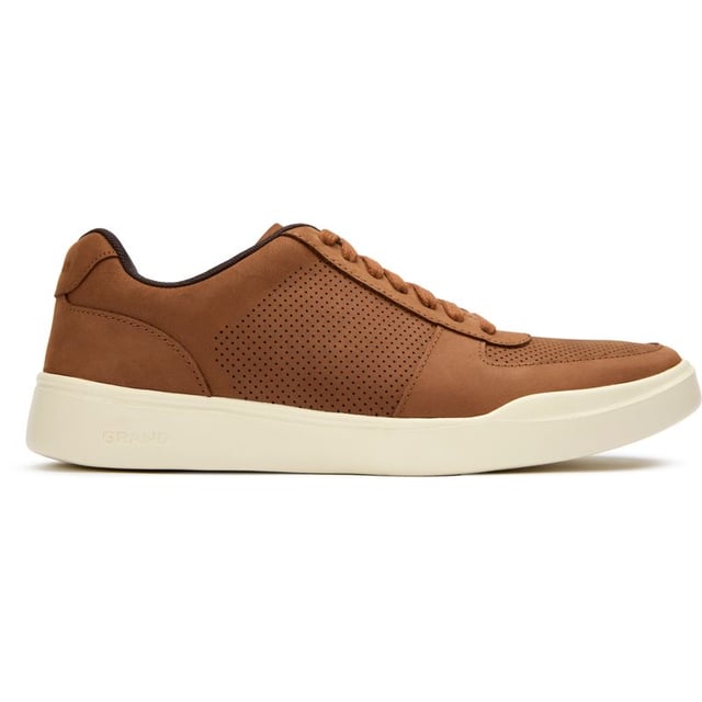 Zapatillas deportivas modernas perforadas Cole Haan para hombre en color tostado, fabricadas con nobuk y suela de goma. Incluyen: diseño de empeine perforado, marca Cole Haan, cuello del talón ligero y acolchado.