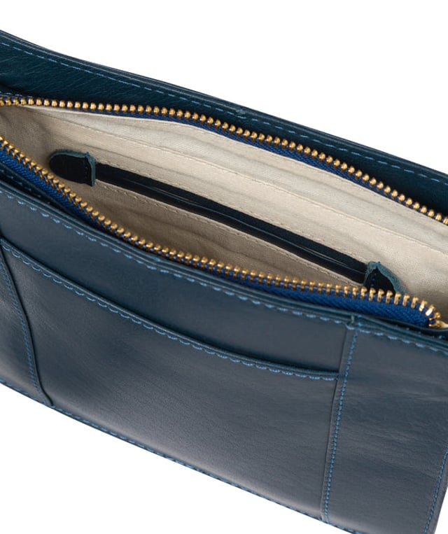 The 'Magda' cross body bag from Conkca London is handcrafted from multi-toned leather for a beautiful finish. A zip-over top opens to reveal a spacious compartment with two slip pockets, lined with natural and untreated 100% cotton. Features a pocket on the front secured with a magnetic press-stud and a slip pocket on the rear, ideal for a smartphone. Comes with an adjustable leather strap with a maximum drop length of 68cm. Adorned with the inimitable Conkca squirrel charm and Conkca logos.