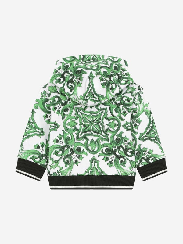 Dolce &amp; Gabbana utilise new technological properties to create captivating aesthetics. This baby boys zip up is a part of the FW24/25 Boy‚ôs Collection that boasts a ‚úcalligraphic-naturalistic‚ù Majolica accent. Crafted in a magnetic two-tone detailing ‚ì bright green and white- cotton jersey design with all-over green majolica print. Inspired by Sicilian tiles, it has ribbed trims and a black script logo on one side. He will be obsessed. ‚ Made in Italy‚ Zip Fastening‚ Machine Wash (30*C)‚ 100% Cotton (Soft Jersey)‚ Lining of Hood: 100% Jersey (Soft Jersey)