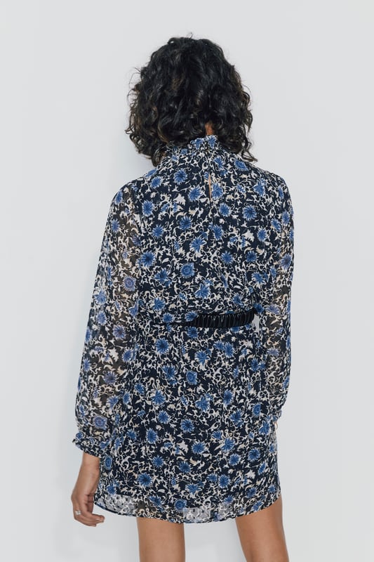 Midi dress with blue anemones, high neck and long sleeves. Elastics at the wrists and collar. Low-necked in the back and button fastening.