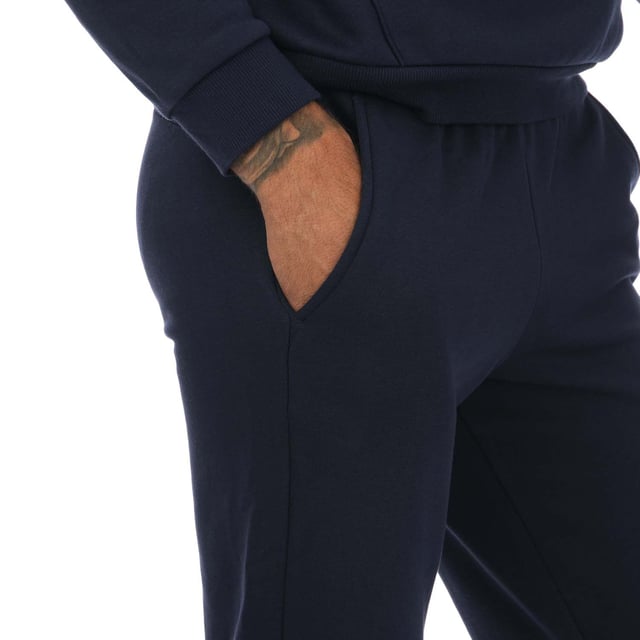 Mens Puma Essentials Logo Sweatpants in navy.- Elasticated waist with inner drawcord.- Two front pockets.- Ribbed ankle cuffs.- Printed branding.- Brushback fleece.- Regular fit.- Shell: 66% Cotton  34% Elastane. Rib: 97% Cotton  3% Elastane.- Ref: 58671476