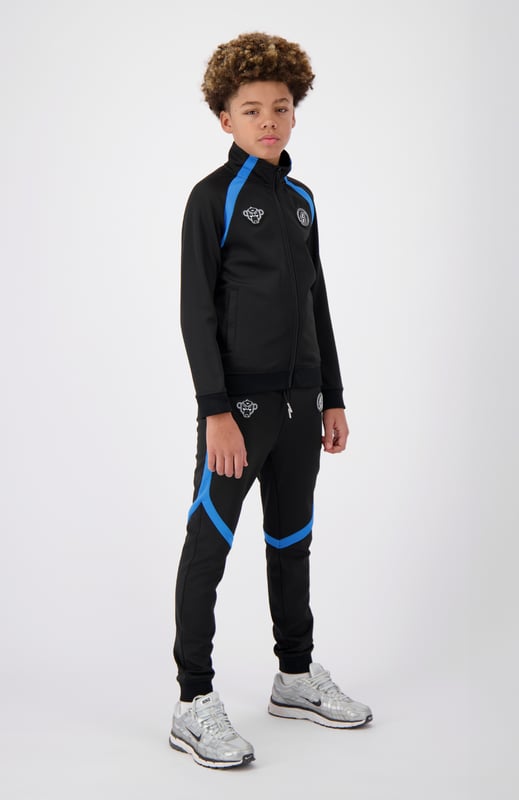 100 % Polyester Normale Passform Zwei Markenpatches auf der Vorderseite Zwei Fronttaschen Mit sportlichen Streifen verziert Kombinierbar mit JR. COMPOUND TRACKTOP 