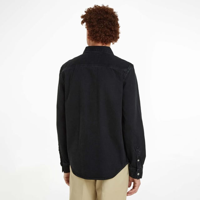 Mens Calvin Klein Logo Patch Denim Shirt in black.- Classic collar.- Front press-stud fastening.- Two chest flap pockets.- Press-stud fastening cuffs.- Faded effect.- Curved hem.- Ref: J30J3258951BY