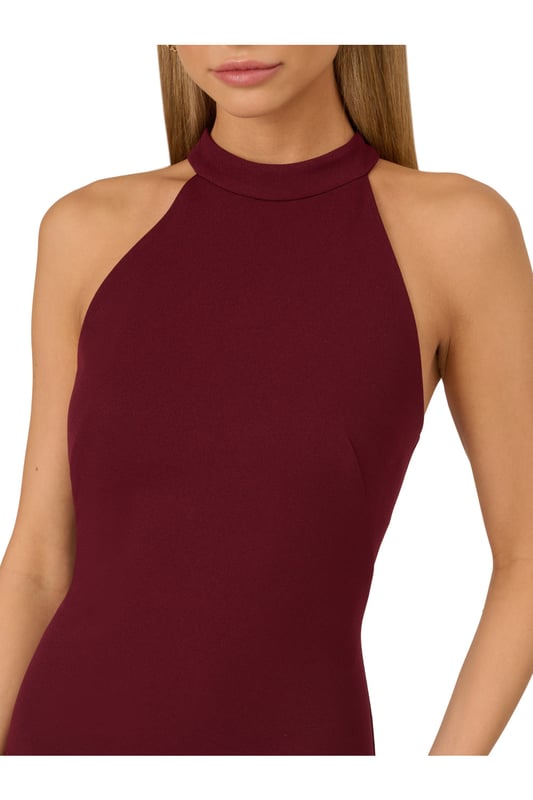 Raise a glass to celebrate all of your upcoming occasions in this eye-catching halter gown. This formal dress features a halter bodice, short mock neckline, and a fitted silhouette that is contrasted by a sheer mesh skirt with ruffle details. Designed with knit crepe that has some stretch and no waist seam for a comfortable and figure-flattering fit, this evening gown is perfect for a formal or black-tie dress code. A hidden zipper closure at the centre back completes this stunning dress. Styled with nude heels and a beaded clutch, this sexy yet sweet gown is a head-turner.
