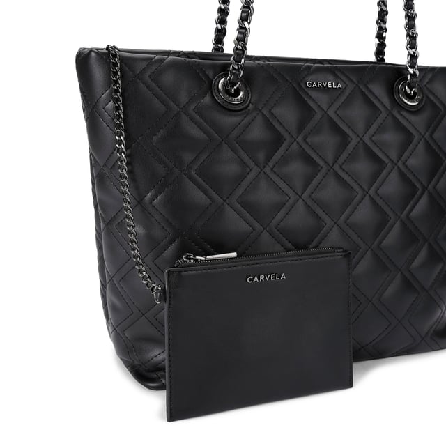 This Carvela Rosa Chain Tote Bag features a black leather alternative exterior with diamond quilting detail. There are two shoulder straps which have gunmetal chain detail to match the branding on the front of the bag. Dimensions: 29cm (H), 34cm (L), 12cm(D). Strap length: 57cm.