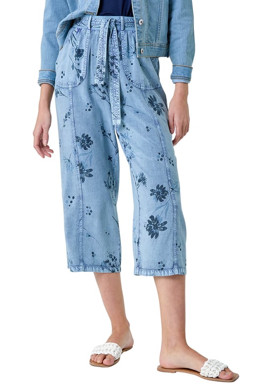 Floral Print Culotte Trousers from Roman. Add a touch of floral flair to your Spring wardrobe with these stylish culotte trousers. Featuring a cute floral print on a denim wash backdrop, these trousers are perfect for the new season. The elasticated waist with a tie belt detail offers both comfort and style, while the cropped culotte length and wide leg shape create a flattering silhouette. The light woven material and pull-on design make them a real Spring staple. Complete your look with a denim jacket, cami top and sandals for effortless daywear.