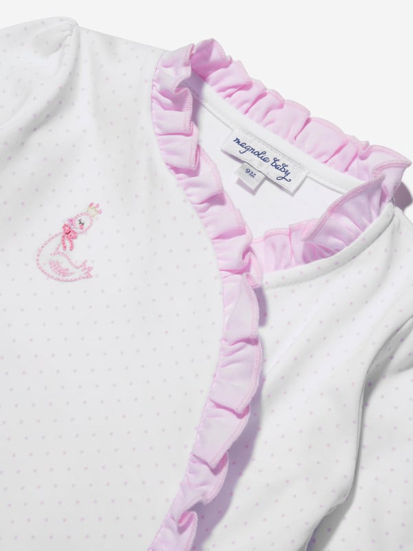 Presenting the Baby Girls Swan Embroidered Cross Ruffle Babygrow in White by Magnolia Baby. A stylishly elegant addition to your Baby_Girl's clothing ensemble. Its key features are:     Chic Design: Elegant swan embroidery makes it an instantly attractive piece. Cross ruffle patterns add an extra flair of sophistication. Supreme Comfort: Crafted with high-end materials for ultimate softness and comfort, ensuring uninterrupted playtimes and peaceful sleep.  Transform your Baby_Girl's attire with this beautiful Swan Embroidered Cross Ruffle Babygrow from Magnolia Baby in white. Make a purchase now and let your little fashionista shine brightly!