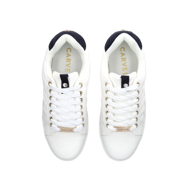 The Joyful Quilt is a white trainer with chevron quilt pattern on the exterior. The front is laced up with gold tone eyelets. The tongue features crystal stud. Gold tone Icon C stud at the back of the ankle.