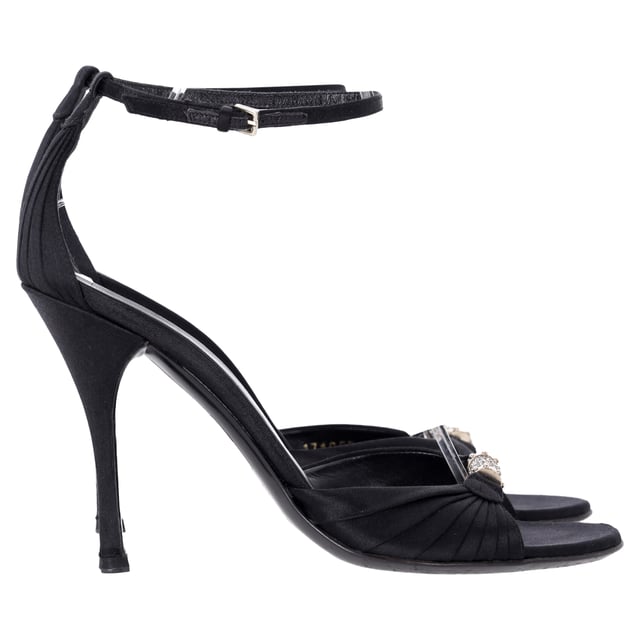 VINTAGE, RRP AS NEW
Elevate your evening ensemble with the Gucci Crystal-Embellished Open-Toe Sandal Heels in luxurious black satin. These stunning heels feature a captivating crystal embellishment that adds a touch of sparkle and glamour, perfect for any special occasion. The open-toe design elegantly showcases your pedicure, while the delicate straps provide a secure fit and enhance the overall allure of the shoe. Crafted from high-quality satin, these sandals not only look fabulous but also offer comfort for all-night wear. Pair them with your favorite cocktail dress or tailored jumpsuit to create a head-turning look that embodies the sophistication of Gucci.

 Gucci Crystal-Embellished Open-Toe Sandal Heels in Black Satin

Condition: Very good
Signs of wear: Minor markings, Lightly used but very well maintained. Minor mark at soles & creasing, light scuffing at the soles and heels.
Packaging: None
Color: Black
Material: Satin | satin
Size: IT38.5/FR39.5/UK5.5/US8.5
Measurements: Heel height: 11; Insole length: 25,5
SKU: NAPPUITSH397907W