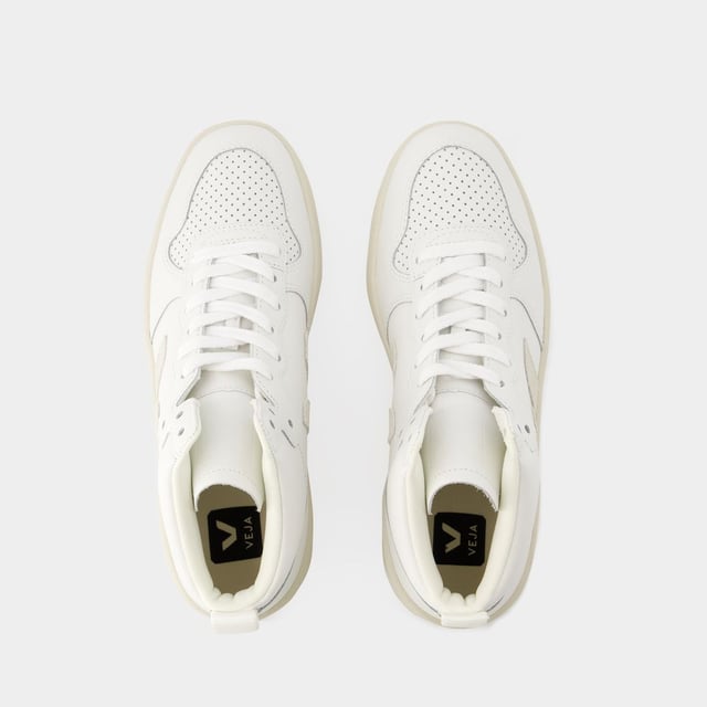 Die Sneakers V-15 von Veja, aus naturweißem Leder, verkörpern die ethische und moderne Ästhetik der Marke. Die Schuhe wurden sorgfältig entworfen und bieten ein klares Design, das durch das hochwertige Leder in seinem natürlichen Farbton hervorgehoben wird. Minimalistische Details und eine langlebige Gummisohle sorgen für einen zeitgemäßen Touch, während sich die umweltbewusste Vision von Veja in jedem Paar widerspiegelt. Die V-15 sind die perfekte Wahl für alle, die auf der Suche nach einem bewussten und trendigen Stil sind. Farbe: weiß - Extra-White_Natural. Farbe: weiß - Extra-White_Marsala_Nautico. Material Sohle: Gummi. Futtermaterial: recyceltes Polyester. Verschluss: einfach reinschlüpfen. Form der Kappe: rund offen. Schuhe: größengerecht - Sizing: Europäisch.