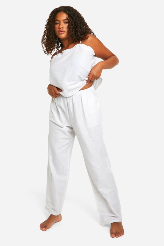 Chic pinstripe pattern for a classic look
        Comfortable cami top with delicate lace trim
        Wide-leg trousers for ultimate relaxation
        Adjustable spaghetti straps for a perfect fit
        Lightweight fabric ideal for year-round wear
    
    Indulge in the perfect blend of comfort and style with this charming plus-size pyjama set. The pinstripe pattern adds a touch of sophistication to your nighttime routine, whilst the soft fabric ensures a cosy night's sleep. The cami top features a flattering lace trim and adjustable straps, allowing you to customise the fit to your liking. Pair it with the wide-leg trousers for a relaxed silhouette that's perfect for lounging. Whether you're settling in for a movie night or enjoying a lazy weekend morning, this versatile set is your go-to choice. The lightweight fabric makes it suitable for all seasons, keeping you cool in summer and comfortably warm in winter. Embrace the effortless chic of this pyjama set and transform your nightwear collection.