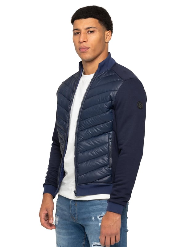 Enzo Milano Mens Hybrid Jacket features a puffer front made from lightweight polyester, which provides excellent insulation. Full zip fastening front with a elasticated collar, long contrast-fabric sleeves with elasticated cuffs. The jacket has 2 secure zip-fastening pockets, 2 inside pockets for additional storage. Finished with Enzo Milano rubberised branding on the left sleeve.