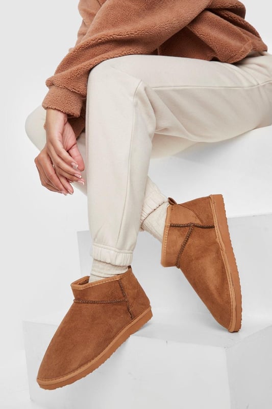 Ultra mini design for a contemporary twist on classic boot styles
        Flat heel between 0 and 2cm for all-day comfort
        Synthetic suede upper for a soft, luxurious feel
        Slip-on style for effortless wear
        Versatile silhouette suitable for various casual occasions
    
    Step into style with these ultra mini shoe boots, a must-have addition to your casual footwear collection. The sleek, low-profile design offers a modern take on traditional boot styles, perfect for the fashion-forward individual. Pair them with cropped jeans and an oversized jumper for a relaxed weekend look, or team with a flowy midi dress for a chic daytime ensemble. The flat heel ensures comfort for extended wear, making these boots ideal for family gatherings, shopping trips, or casual outings with friends. Their versatility allows for seamless transition from day to night, offering endless styling possibilities for the contemporary British fashionista. Embrace the latest trends while prioritising comfort with these ultra mini shoe boots, a true embodiment of Boohoo's commitment to accessible, on-trend fashion.