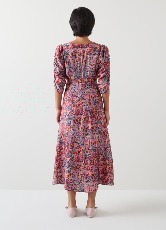 Experience an enchanting garden with the Erin petite watercolour floral jacquard dress. In a delicate pink silk, it features a V neck, full length sleeves, and an exquisite jacquard base with a back zip for a flawless fit. Perfect for evening occasions, it pairs beautifully with subtle gold accessories and elegant heels.