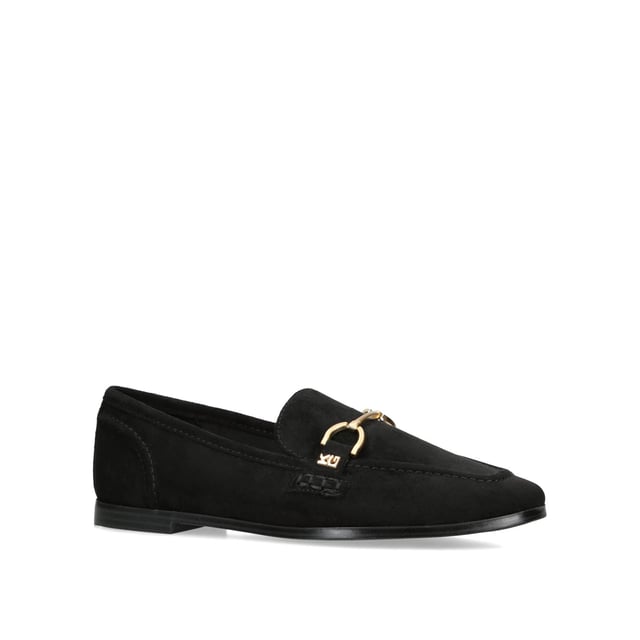 The KG Kurt Geiger Madeline is a black microsuede slip on loafer. There is an antiqued brass horse bit chain across the toe and small KG Kurt Geiger stud.