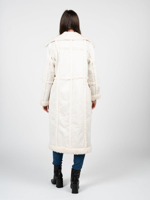 De jas van imitatiebont is de perfecte combinatie van elegantie en comfort, geschikt voor elke situatie, ongeacht de gelegenheid.

De uniforme kleur van de jas maakt hem extreem veelzijdig en makkelijk te combineren met verschillende stijlen, van casual tot meer formeel.

Grote metalen knopen met een merkelement geven de jas een uniek karakter en benadrukken de hoge kwaliteit en aandacht voor detail.

Diepe zakken aan de voorkant voegen niet alleen functionaliteit toe door het opbergen van noodzakelijke kleine items, maar zorgen ook voor extra comfort en warmte op koelere dagen.