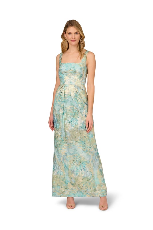Fine fabrication and elegant details make this floral gown stand above the rest. This floral dress features a fitted bodice with square neckline and tank straps, a floor-skimming skirt with a slit at the back, and pleated details at the waist that shows off the figure. Crafted from woven metallic jacquard fabric source from Korea, this dress is decked out in beautiful floral print. A low back and hidden zipper closure are the final details that make this evening gown shine. Styled with nude heels and sparkling jewelery, this floral gown is perfect for a formal or black-tie event.