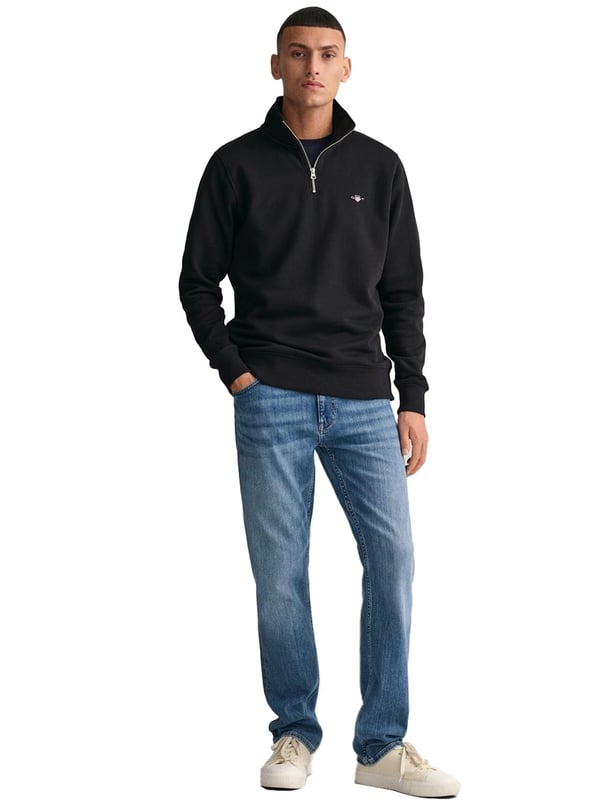 This versatile half-zip sweatshirt combines comfort and style with a premium cotton-polyester blend that's perfect for transitional weather. Featuring a small, intricately embroidered GANT graphic on the chest, it showcases a subtle yet elevated design. The ribbed hem and cuffs create a tailored silhouette. Designed for a regular fit, the half-zip collar adds a touch of sporty elegance, while the durable fabric ensures long-lasting wear.