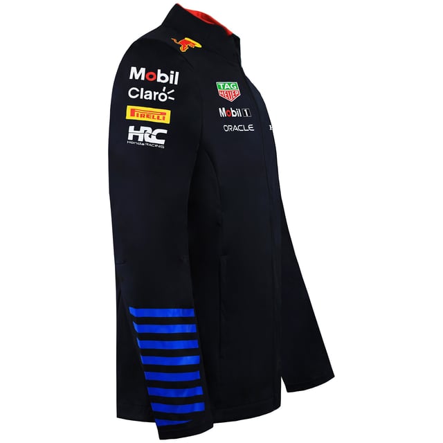 Red Bull Racing F1 Team 2024 Unisex-Softshelljacke in Marineblau Bereite dich auf die Saison vor mit der Red Bull Racing F1 Team 2024 Unisex Navy Softshelljacke – die perfekte Kombination aus Performance, Schutz und Style. Diese Jacke wurde sowohl für eingefleischte Fans als auch für aktive Menschen entwickelt und bietet zuverlässigen Wetterschutz sowie einen eleganten, modernen Look, was sie zu einem unverzichtbaren Teil der offiziellen Red Bull Racing Fanartikel macht. Wichtige Eigenschaften: Hochwertiges Softshell-Material: Hergestellt aus wasser- und windabweisenden Materialien bietet diese Jacke Komfort und Schutz bei wechselnden Wetterbedingungen. Modernes Unisex-Design: Mit vielseitiger Passform und elegantem Navy-Finish – perfekt, um deine Leidenschaft für die F1 mit Stil und Raffinesse zu präsentieren. Authentisches Team-Branding: Verziert mit offiziellen 2024 Red Bull Racing Logos und Designdetails, die das Erbe und die Innovation des Teams feiern. Funktionale Designelemente: Ausgestattet mit einem sicheren Reißverschluss vorne, verstellbaren Bündchen und durchdachten Taschen für mehr Komfort und verbesserte Leistung. Leicht und atmungsaktiv: Die für den aktiven Einsatz konzipierte Jacke bietet Atmungsaktivität und Bewegungsfreiheit und ist somit ideal für Renntage, Reisen oder alltägliche Abenteuer. Werten Sie Ihre Fan-Garderobe auf und bleiben Sie den Elementen immer einen Schritt voraus mit der Red Bull Racing F1 Team 2024 Unisex Navy Softshell-Jacke, bei der topaktuelles Design auf unschlagbare Leistung auf und abseits der Strecke trifft.