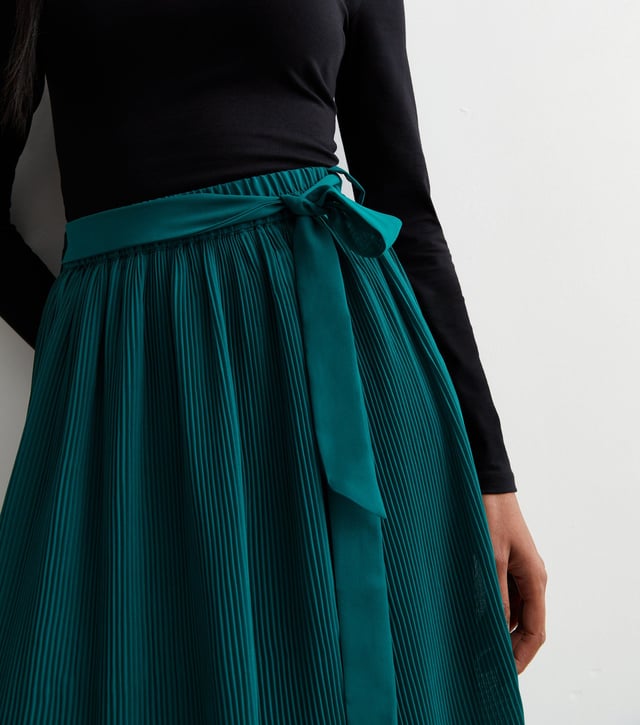 Esta falda midi plisada verde con detalle de cinturón está diseñada por expertos con un corte midi y confeccionada en un tejido vaporoso de tacto ligero con detalles de cinturón. Su silueta contemporánea es favorecedora y atemporal, perfecta para cualquier ocasión.