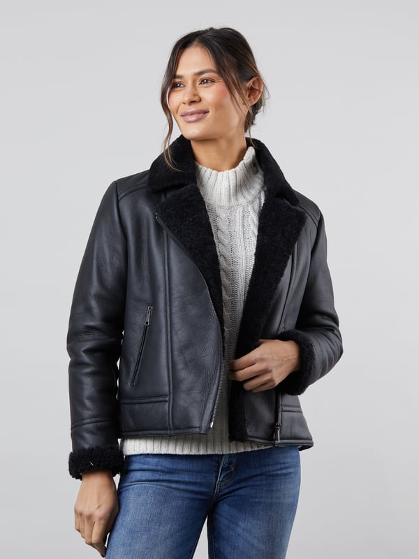 Lindeth Sheepskin Aviator Jacket in Black Our new-in flattering Lindeth aviator jacket is crafted in rich sheepskin with a smooth external nappalan finish. The black colourway is elegant and timeless and you can pair this jacket easily with your favourite knits to stay cosy all winter long.Featuring an asymmetric zip front inspired by biker jackets, the snuggly lapel collar and cuffs will keep you warm and cosy when the chilly weather comes around. Plus you can keep your hands extra warm with two handy front zip pockets.Sheepskin is nature's finest insulator and temperature regulator, meaning you will stay unbelievably warm and comfortable without overheating. The Lindeth jacket truly is the perfect investment for years to come.Sizing InformationThese measurements are based on a size 12 and will vary slightly between sizes.Approximate centre back length: 61cmApproximate sleeve length from shoulder to cuff: 62cm Approximate sleeve length from underarm to cuff: 45cmThe DetailsStyle Name: Lindeth Sheepskin Aviator JacketColour: BlackMaterial: 100% sheepskin with a nappalan finishFit: True fitAsymmetric front zip fasteningSheepskin lapel collarTwo front zip pocketsSheepskin cuffsAnd on the inside100% sheepskin