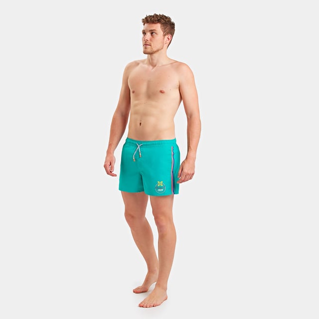 Bañador bóxer Munich.
Cinturilla elástica, ajustable mediante cordones.
Dos bolsillos abiertos con forro de rejilla, en los laterales.
Parche con el nombre de la marca el lateral inferior.
Bolsillo con cierre de solapa y velcro, en la parte trasera.
Bolsillo interior en la parte delantera.
Forro interior de rejilla.
Costuras vistas a tono.
 Composición: 100% Poliester
 Cuidados:
Instrucciones de lavado: 
-Lavar a mano