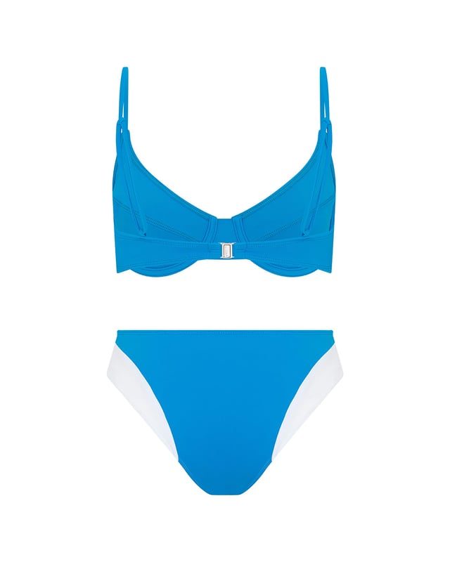 This hipster bikini bottom seamlessly combine style and function, with a blue Brazilian style silhouette and contrasting white contour panelling for fuller coverage. Between sunlounger and jetski or deep diving to the ocean floor, this sustainable piece works everywhere. Pair with the matching blue wired balconette bikini top for the full look.