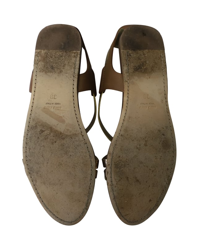 VINTAGE, UVP WIE NEU  
Das goldene Riemen-Detail kennzeichnet diese Gladiatorensandalen von Miu Miu. Hergestellt aus Leder, können diese Gladiatorensandalen dich überall hin begleiten und lassen sich perfekt mit deinen Lieblingsjeans kombinieren. Stylen Sie diese Sandalen mit einer Jeans und einem T-Shirt und sehen Sie dennoch entspannt schick aus.  

Miu Miu Gladiator Flache Sandalen aus goldfarbenem Leder  
Zustand: Gut, kommt mit Schuhkarton  
Abnutzungserscheinungen: Starke Abnutzung an der Sohle und Falten im Leder  
Material: Leder  
Größe: 38/US8  
SKU: 159856  