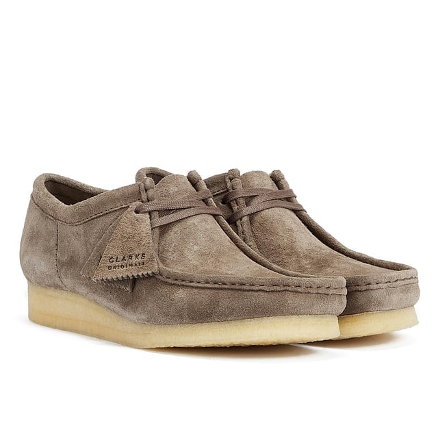 These shoes feature suede uppers, flat laces, and tonal fobs, marking Clarks' commitment to quality. They are complete with natural crepe soles, ensuring both style and comfort.