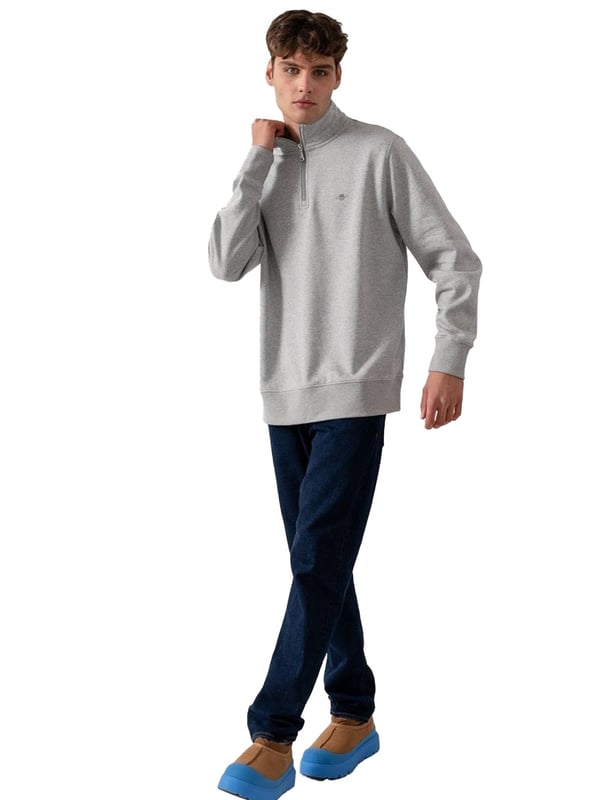 This versatile half-zip sweatshirt combines comfort and style with a premium cotton-polyester blend that's perfect for transitional weather. Featuring a small, intricately embroidered GANT graphic on the chest, it showcases a subtle yet elevated design. The ribbed hem and cuffs create a tailored silhouette. Designed for a regular fit, the half-zip collar adds a touch of sporty elegance, while the durable fabric ensures long-lasting wear.