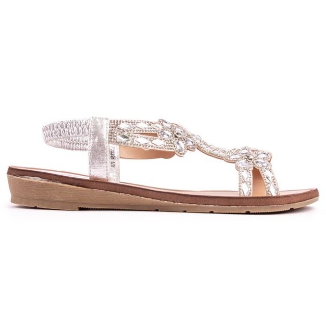Añade un poco de glamour a tu despreocupación. felices conjuntos de verano con estos cómodos. Sandalias planas plateadas Solesister April para mujer con correas superiores bellamente adornadas y una correa elástica en el talón para un ajuste perfecto. Estos zapatos planos fáciles de usar tienen un aspecto deslumbrante y son flexibles. Suela ligeramente acuñada.