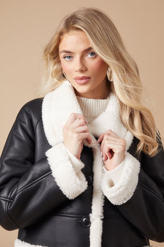 Luxurious shearling-style lining for ultimate warmth
        Oversized fit for effortless layering
        Contrasting patch pockets add a stylish touch
        Notched lapel collar for a classic look
        Long-line silhouette offers versatile styling options
    
    Embrace the chill with this striking bonded shearling coat from Oasis. The contrasting exterior and plush interior create a bold, eye-catching look that's perfect for making a statement on cooler days. Its relaxed fit allows for easy layering over your favourite jumpers and dresses, while the long-line silhouette provides ample coverage and warmth. Style it with slim-fit trousers and ankle boots for a chic daytime ensemble, or throw it over a floral midi dress for a pretty contrast at casual gatherings. The versatile design makes it an ideal choice for everything from weekend brunches to family outings. For a more polished look, cinch the waist with a statement belt to create definition and showcase your personal style.