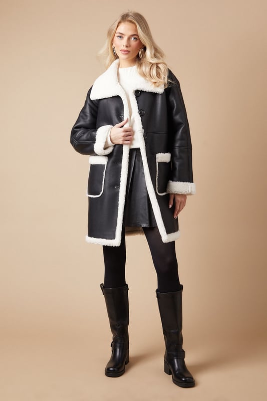 Luxurious shearling-style lining for ultimate warmth
        Oversized fit for effortless layering
        Contrasting patch pockets add a stylish touch
        Notched lapel collar for a classic look
        Long-line silhouette offers versatile styling options
    
    Embrace the chill with this striking bonded shearling coat from Oasis. The contrasting exterior and plush interior create a bold, eye-catching look that's perfect for making a statement on cooler days. Its relaxed fit allows for easy layering over your favourite jumpers and dresses, while the long-line silhouette provides ample coverage and warmth. Style it with slim-fit trousers and ankle boots for a chic daytime ensemble, or throw it over a floral midi dress for a pretty contrast at casual gatherings. The versatile design makes it an ideal choice for everything from weekend brunches to family outings. For a more polished look, cinch the waist with a statement belt to create definition and showcase your personal style.