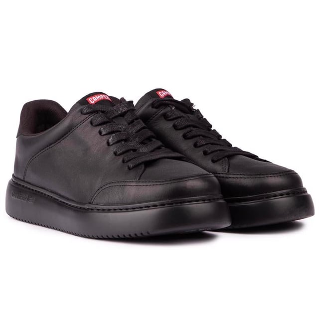 Runner K21 es la última incorporación a la colección Runner de Camper con un enfoque de inspiración retro y mayor volumen. Esta zapatilla de cuero negro para hombre tiene una plantilla extraíble OrthoLite® Recycled™ y suelas XL EXTRALIGHT® Organix™ (30 % de caña de azúcar de origen biológico).