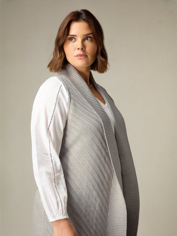 In stylish grey, this sleeveless cardigan is knitted from a soft, fine knit and has a flattering longline shape. With a shawl collar and softly draping front, its the perfect piece to layer over a T-shirt or blouse as the weather grows chillier.