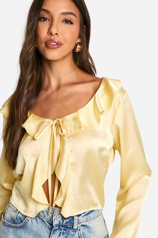 Satin Ruffle Tie Front Blouse A loose-fitting, lightweight garment with a feminine feel, a blouse is the ultimate wardrobe staple that never goes out of style. Floaty, chic, and far from basic, go from day to night with this classic piece. Whether you choose a floral blouse with jeans for a low-key vibe or drop jaws with a classic satin blouse and trousers, you'll be reaching for this style season after season. Seen in updated prints and classic neutrals, we're talking minimal effort, maximum payoff.Style: BlouseDesign: PlainFabric: SatinLength: RegularNeckline: V NeckSleeve Length: Long Sleeve