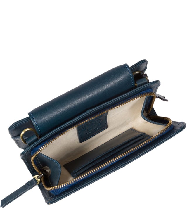 The 'Little Wonder' cross body clutch bag from Conkca London is handcrafted from multi-toned leather for a beautiful finish. A magnetic press-stud secured cover opens to reveal a compartment ideal for a smartphone. A zip-over top opens to reveal a second compartment that is perfect for your essential items and has three handy card slots. Lined with natural and untreated 100% cotton. It comes with an adjustable leather strap with a maximum drop length of 68cm, which is removable, converting the bag into a clutch bag. Adorned with the inimitable Conkca squirrel charm and Conkca logos.