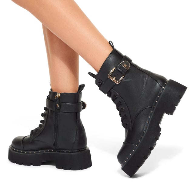 This KG Kurt Geiger Trick Lace Up Boot is a combat style boot with a gold tone buckled strap at the ankle. There is corresponding gold studs around the midsole.