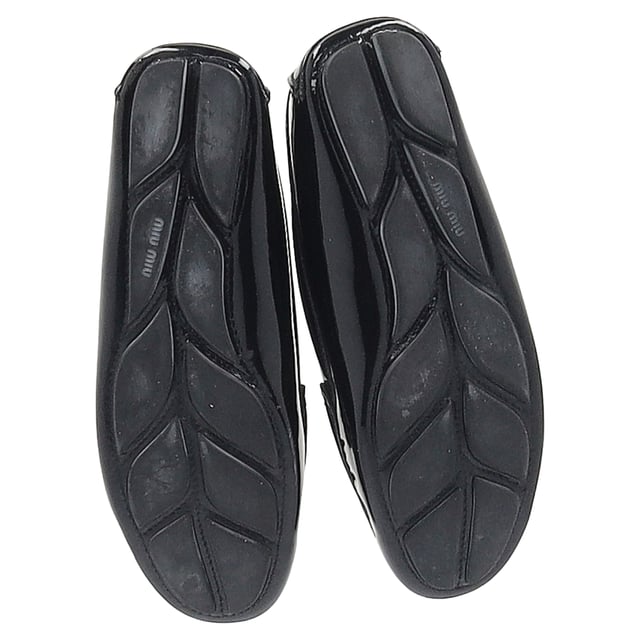 VINTAGE, NP WIE NEU  
Tauchen Sie ein in die Raffinesse mit den Crystal Detail Loafers von Miu Miu aus schwarzem Lackleder. Diese auffälligen Slipper zeichnen sich durch ein elegantes schwarzes Lacklederfinish aus, das mit funkelnden Kristallelementen verziert ist, die einen Hauch von glamourösem Flair verleihen. Das zeitlose Design der Slipper wird durch diese markanten Details aufgewertet, wodurch sie sowohl für berufliche Umgebungen als auch für Abendveranstaltungen perfekt geeignet sind. Erleben Sie die perfekte Mischung aus Eleganz und Glanz mit jedem Schritt, den Sie machen.  

Miu Miu Crystal Detail Loafers aus schwarzem Lackleder  

Zustand: Sehr gut  
Abnutzungserscheinungen: Sehr leichte Markierungen an Sohlen und Innensohlen.  
Verpackung: Keine  
Farbe: Schwarz  
Material: Leder | Lackleder  
Größe: EU37/UK4/US7  
Maße:  
SKU: TONPUGBSH377100W
