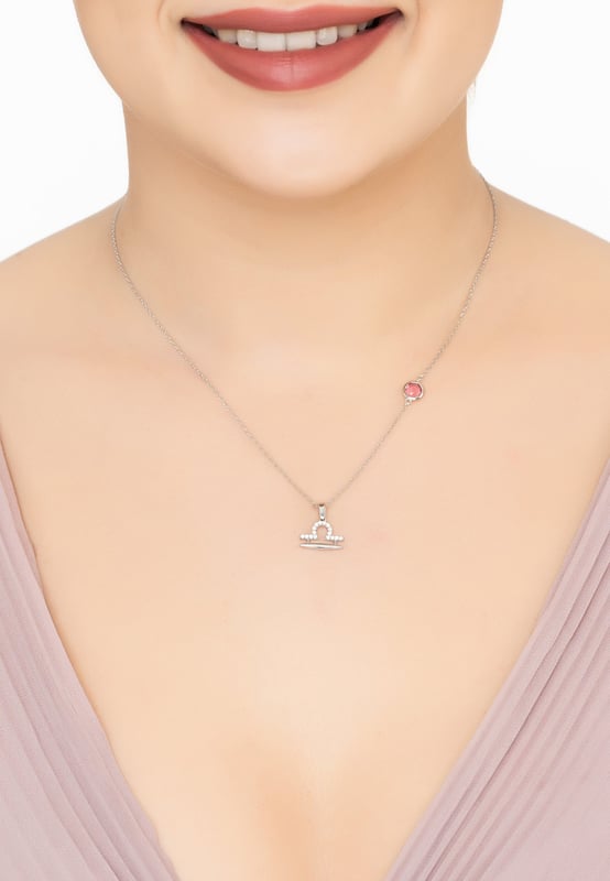 The Zodiac Libra Birthstone Necklace Pink Tourmaline Silver presents the scales' constellation in cubic zirconia, elegantly leading to a lab-created Pink Tourmaline which is set along the 40-45cm chain. This piece, set in 925 sterling silver, mirrors Libra's pursuit of balance and harmony, with Pink Tourmaline fostering compassion and gentleness, aligning with Libra's diplomatic nature in the stars.If you celebrate a birthday between Sep 23 - Oct 22, find harmony with this zodiac necklace. This balanced piece celebrates Libra's love for beauty and equilibrium, making it an ideal accessory for those who seek serenity.