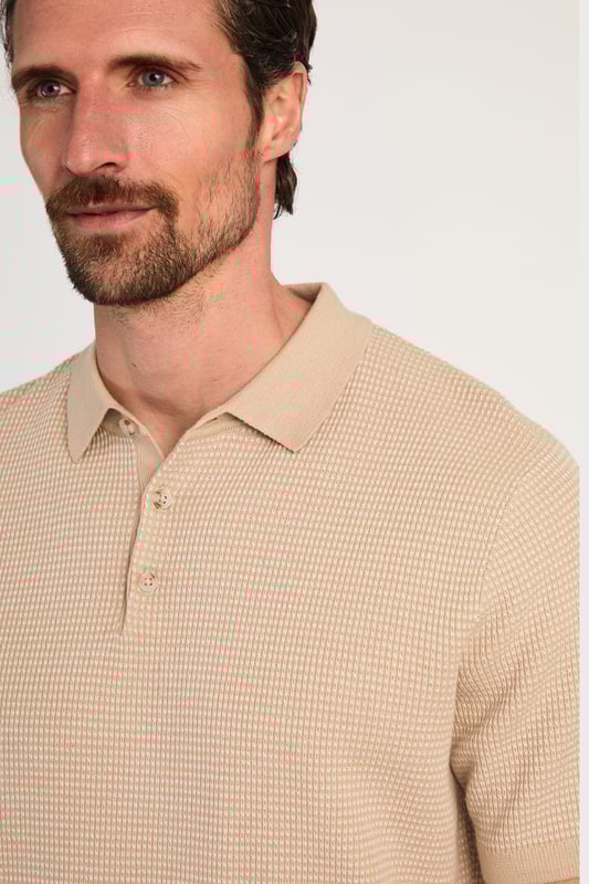 This textured polo shirt from Kensington Eastside blends classic sophistication with modern design. Crafted from a premium knit fabric with a subtle pattern, it offers a refined yet contemporary look. Lightweight and breathable, it’s a versatile choice for smart-casual occasions, ensuring style and comfort effortlessly. Made from 100% Cotton.