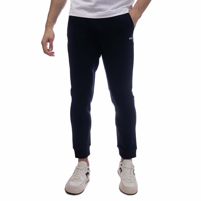 Mens BOSS Hadiko 1 Tracksuit Bottoms in dark blue.- Elasticated waist with drawcord.- Front slant pockets.- Rear patch pocket with repeat embroidered logo stripes.- Ribbed cuffs.- Embroidered BOSS logo at left thigh.- 47% Cotton  46% Polyester  7% Elastane.  Machine washable.- Ref: 50497194402
