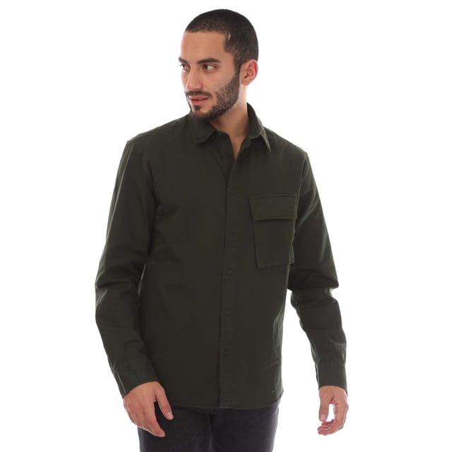 Mens Belstaff Garment Dye Cotton Scale Shirt in green.- Point collar.- Centre front button fastening.- Signature tilted flap pocket.- Adjustable buttoned cuff.- Belstaff Phoenix patch on sleeve.- Garment-dyed cotton twill.- 100% Cotton.- Ref: 104537TLGRN